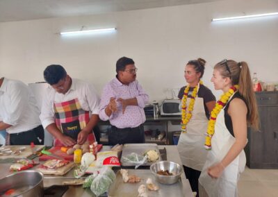 a group of people standing around a table with food