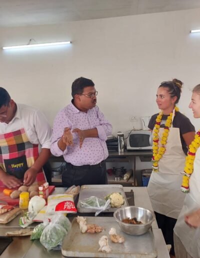 a group of people standing around a table with food