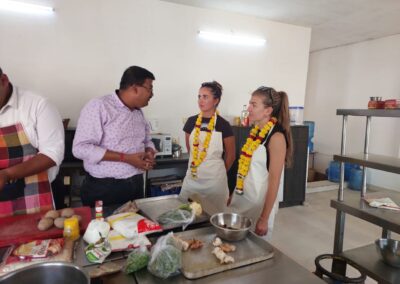 a group of people standing around a table with food